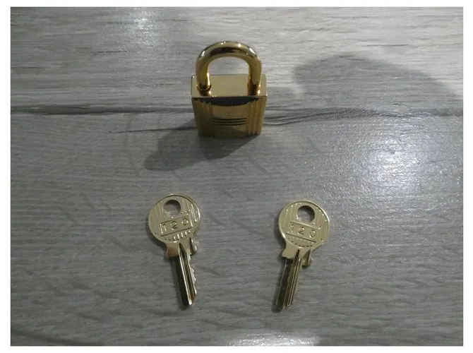 Candado de acero dorado Hermès con 2 llaves Gold hardware 